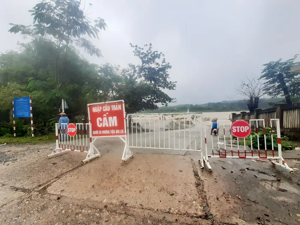 Mặc dù đã cấm người và phương tiện qua lại nhưng bên đường qua cầu tràn vẫn có xe máy, xe tải đang vượt qua cầu