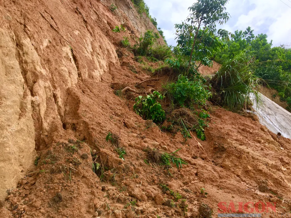 Phía trên sườn núi, hàng khối đất đá đổ xuống tạo thành vết trượt dài, hố sâu nguy hiểm. Ảnh: TIẾN DŨNG