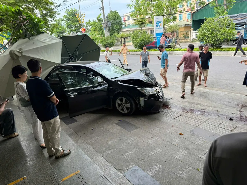 Chiếc xe ô tô màu đen biển số 76A lao lên vỉa hè, tông vào cây xanh mới dừng lại ô tô