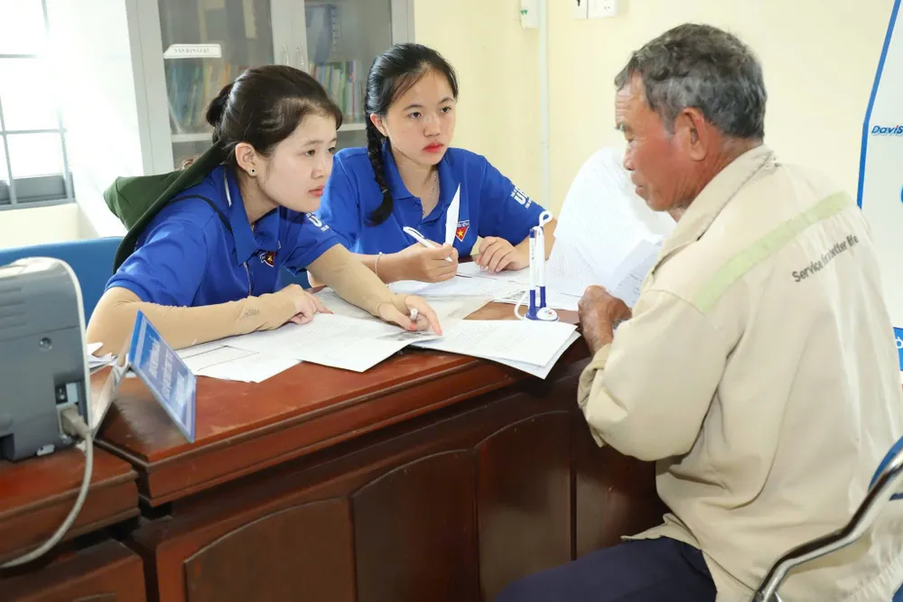 Thanh niên tình nguyện xã Vạn Tường hướng dẫn người dân tiếp cận thủ tục hành chính, dịch vụ công. Ảnh: NGUYỄN TRANG đội hình (4).jpg