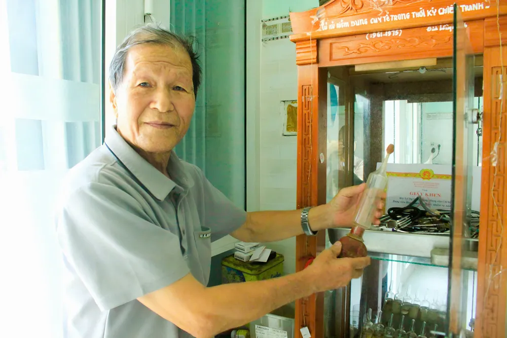 Ông Khánh trân trọng từng dụng cụ y tế từng đồng hành với ông suốt thời chiến tranh. Ảnh: NGUYỄN TRANG ông đinh hồng khánh