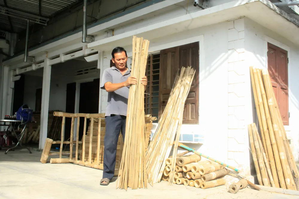 Ông Phương sắp xếp các thanh tre để chuẩn bị đóng vạt giường. Ảnh: NGUYỄN TRANG xóm giường (14).jpg