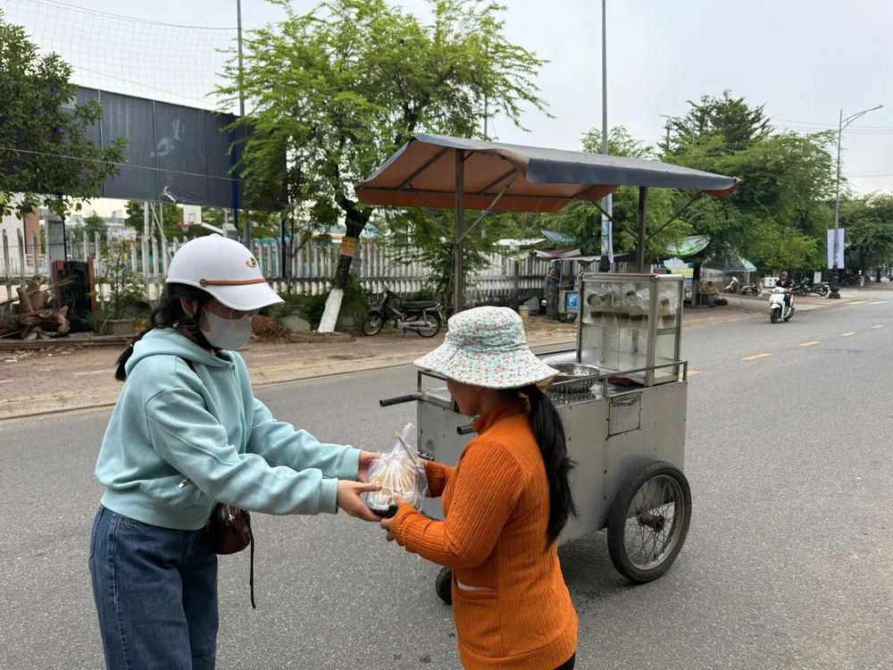 Người buôn bán trên đường bất ngờ khi nhận được bữa trưa từ Hội Người khuyết tật. Ảnh: NGUYỄN TRANG ảnh (3).jpg