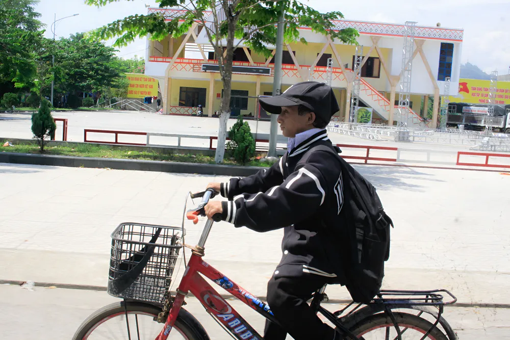 Nhiều người đã quen hình ảnh cậu bé lớp 12 nhỏ nhắn trên chiếc xe đạp dành cho học sinh tiểu học. Ảnh: NGUYỄN TRANG câu bé (10).jpg