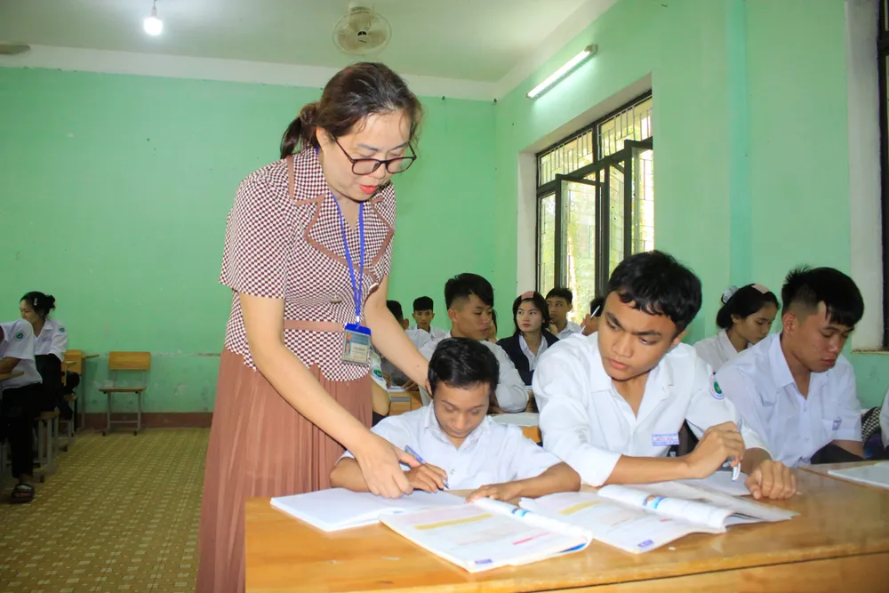 Cô giáo Võ Thị Bích Hiệp đang hướng dẫn em viết từ vựng tiếng Anh. Ảnh: NGUYỄN TRANG ti hon 8 (1 of 1).jpg