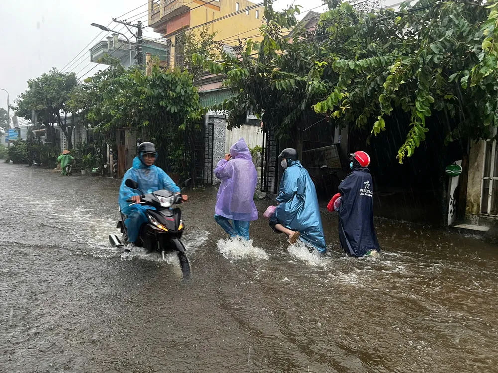 Người dân di chuyển về nhà khi nước đã ngập sâu. Ảnh: NGUYỄN TRANG bình dương (16).jpg
