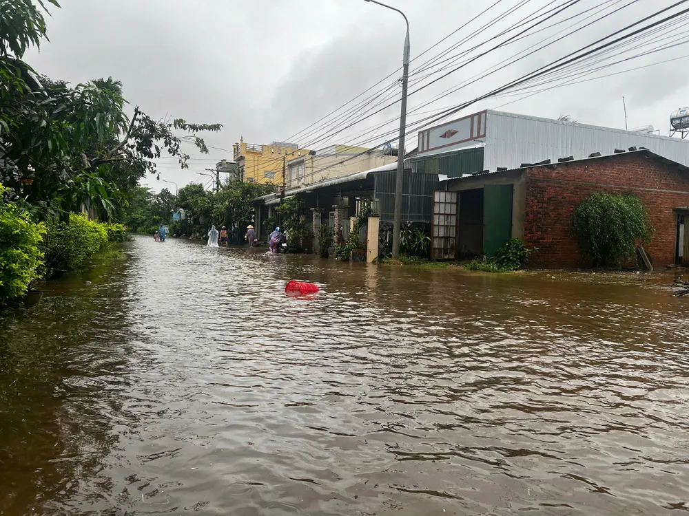 Người dân lội bộ để về nhà vì nước đã ngập sâu. Ảnh: NGUYỄN TRANG bình dương (3).jpg