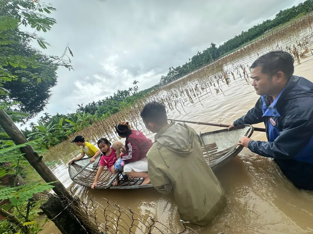 Đưa trẻ em và phụ nữ ra khỏi vùng ngập lụt. Ảnh: XÃ NGHĨA HÀNH nghãi hành.jpg