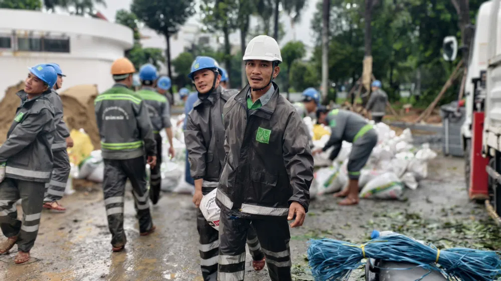 Arbetare bär sandsäckar att släppa ner i kanalen trà khúc (5).jpg