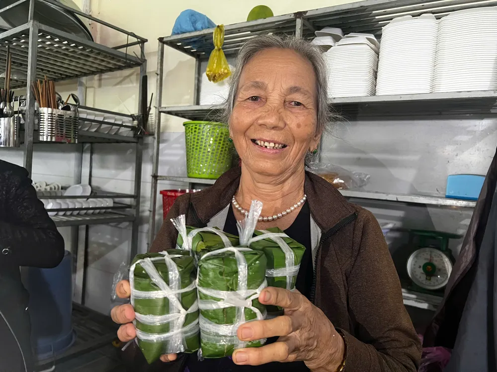 Cụ bà vừa gói xong những chiếc bánh chưng để gửi về vùng lũ. Ảnh: NGUYỄN TRANG bánh chưng (2).jpg
