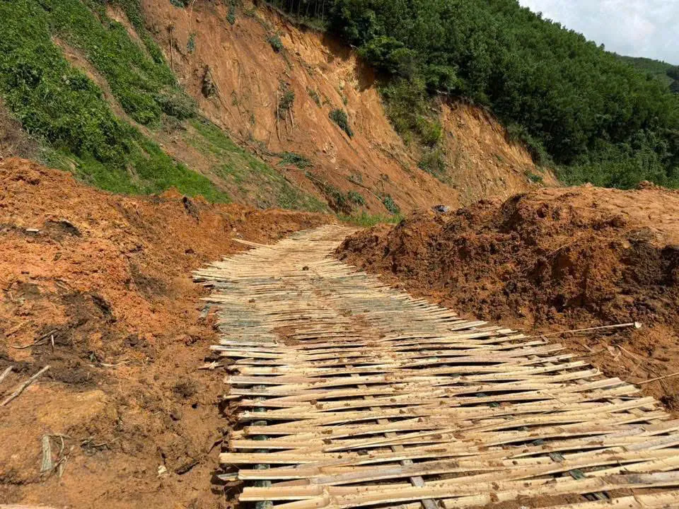 Một đoạn vào thôn Nước Vương bị lún sau sạt lở, người dân đã nghĩ cách đan tấm lồ ô để làm đường. Ảnh: PHẠM THỊ TRẦM trầm