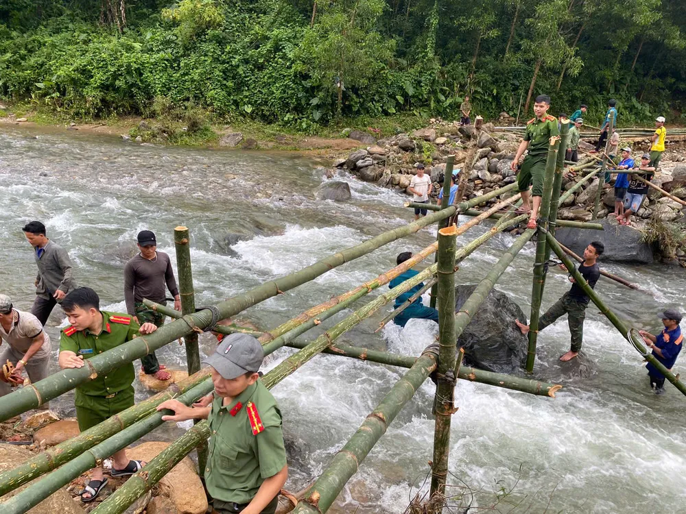 Công an xã Ba Xa cùng người dân dựng cầu tre qua suối. Ảnh: XÃ BA XA