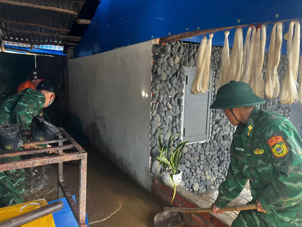 การทำความสะอาดทรายและดินที่ไหลบ่าเข้าบ้านเรือนประชาชนเนื่องจากน้ำขึ้นสูง ภาพ: NGUYEN TRANG vạn tường nguyễn trang (2).jpg