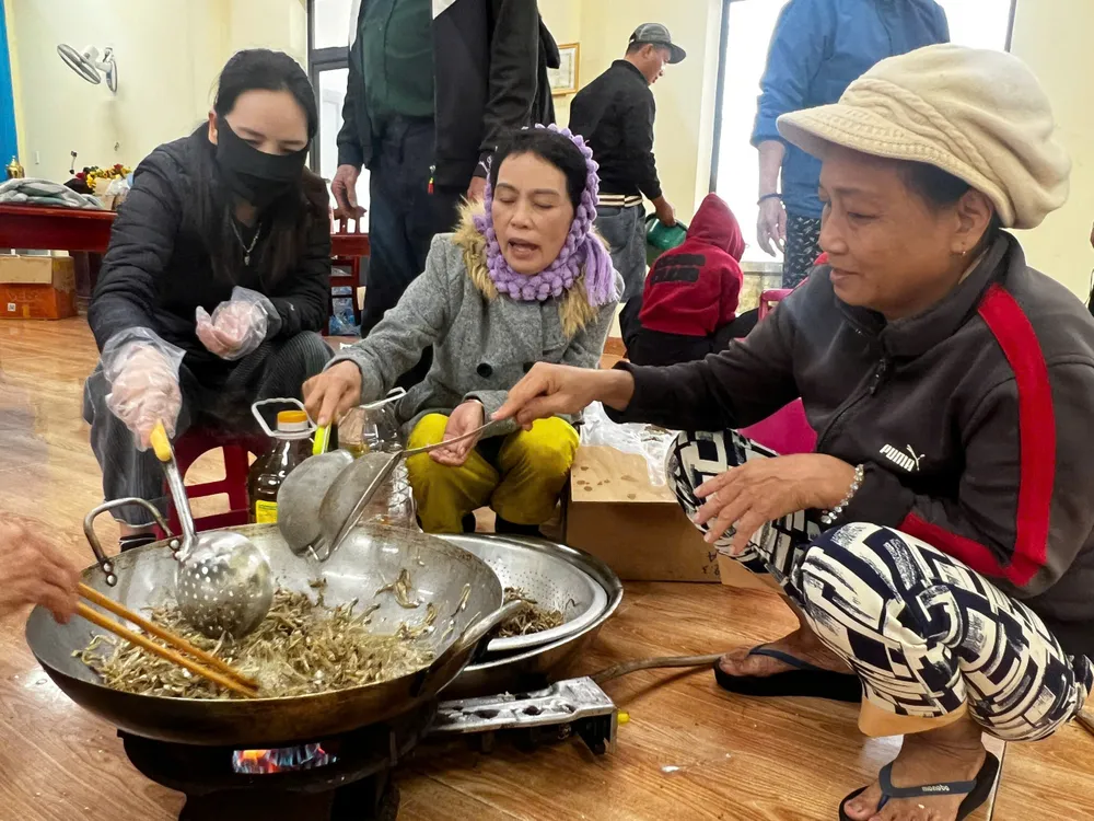 Người dân thôn Phước Thiện 1 cùng nhau làm cá cơm rim hỗ trợ cho người dân vùng lũ Nam Trung bộ. Ảnh: NGUYỄN TRANG