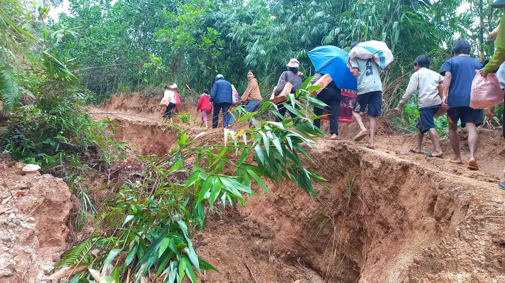 ប្រជាពលរដ្ឋដឹកទំនិញ និងសម្ភារៈចាំបាច់ពីខាងក្រៅចូលក្នុងភូមិតាមផ្លូវដែលរងការបាក់ដី។ រូបថត៖ ង្វៀន ត្រាង tra oi 9 (1 of 1).jpg