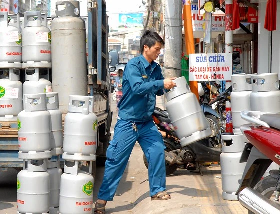 Đưa gas vào một cửa hàng cung ứng cho người dân. Ảnh: CAO THĂNG