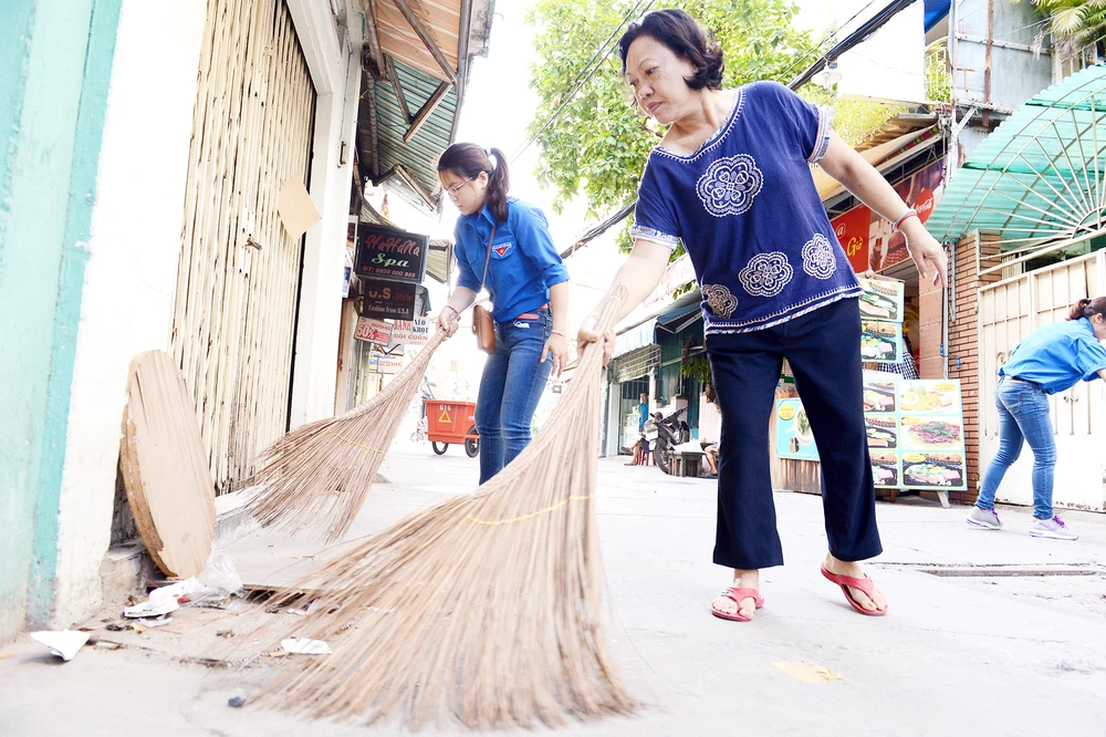  Người dân tham gia dọn dẹp vệ sinh ở một khu phố tại TPHCM. Ảnh: VIỆT DŨNG