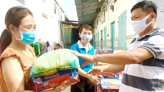 Anh Lương Ngọc Nhẹ, chủ nhà trọ ở ấp 5, xã Thạnh Phú, huyện Vĩnh Cửu, tỉnh Đồng Nai trao quà hỗ trợ công nhân ở trọ. Ảnh: TIẾN MINH