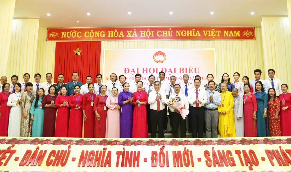 Đồng chí Nguyễn Phước Lộc tặng hoa chúc mừng ủy viên Ủy ban MTTQ Việt Nam phường Tân Thành. Ảnh: TRÚC GIANG sggploc1.jpg