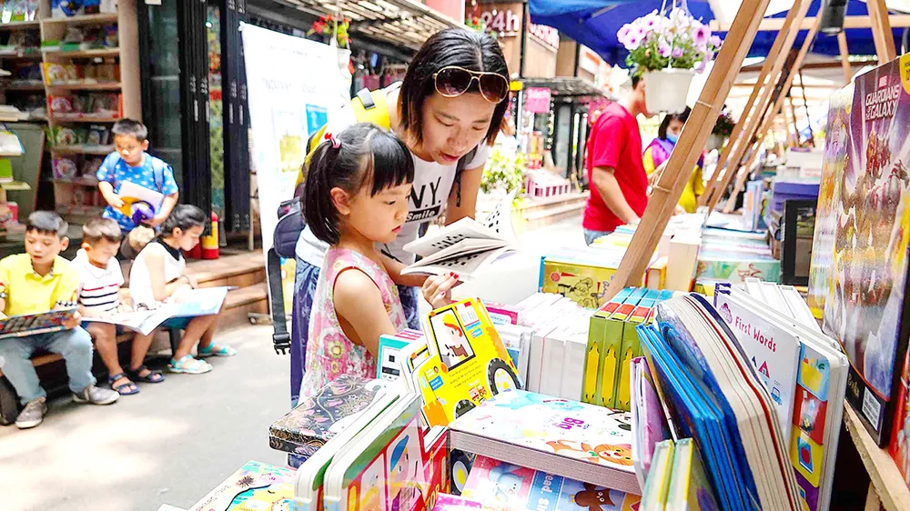 Mẹ và bé lựa chọn sách cho ngày xuân (chụp tại Đường sách TPHCM sáng 12-2). Ảnh: DŨNG PHƯƠNG 