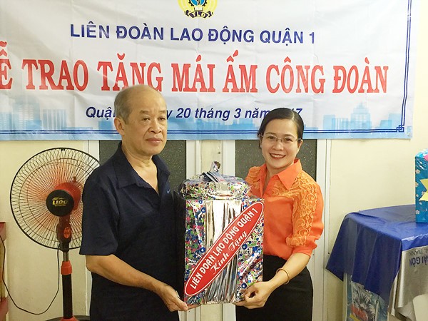 第一郡勞動聯團代表向阮智明移交溫情屋和贈送禮物。