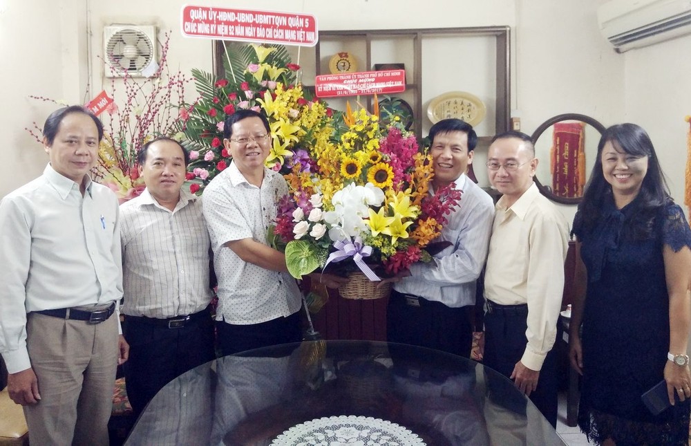 市委代表向本報贈送鮮花祝賀。