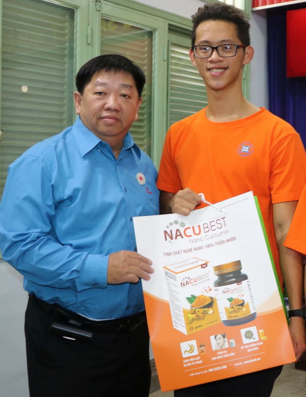 市紅十字會副主席、溫陵會館理事長張子諒(左)贈送禮物予落葉劑受害者。