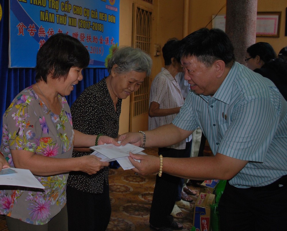 溫陵會館理事長張子諒向長者贈送扶助金。