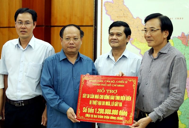 市委常務副書記畢成剛(左二)將12億元的救助金交予奠邊省祖國陣線委員會常務主席陳文山。（圖源：越通社）