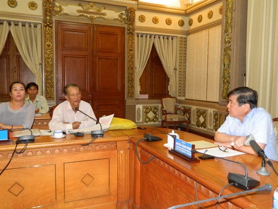 市人委會主席阮成鋒(右)在聽取市民阮清講的意見。（圖源：潘英）