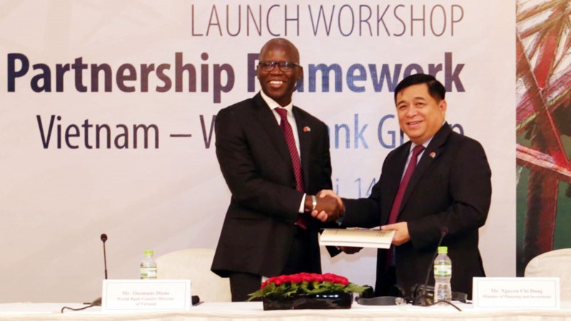 世界銀行駐越南國家首席代表奧斯曼‧迪奧主任將2017-2022年階段越南國家合作夥伴框架文件交予計劃與投資部部長阮志勇。（圖源：陳越）
