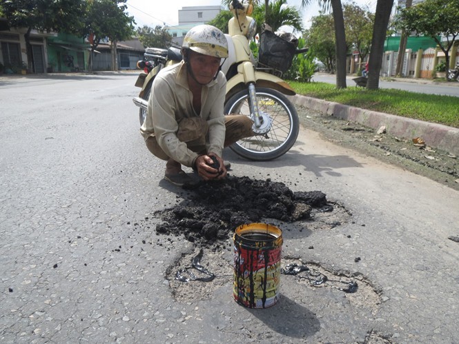 梅文福先生正在修補路面。