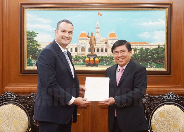 市人委會主席阮成鋒(右)向加拿大駐本市新任總領事凱爾‧努納斯(Kyle Nunas)贈送紀念品。(圖源：市黨部新聞網)