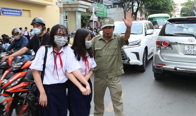 民兵協助學生過馬路維持交通秩序。