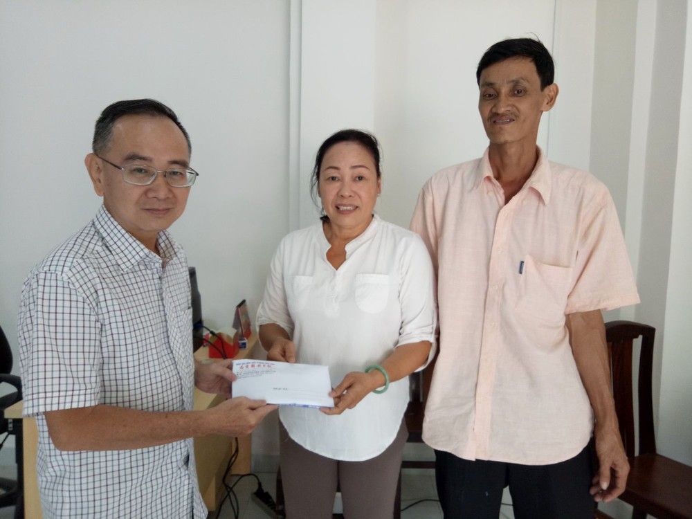 圖1：本報編委兼編輯部主任范興亦把建屋經費轉交予第八郡紅十字輔助會會計阮氏理。