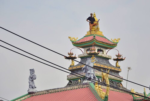 疑吸冰毒青年爬上安富廟屋頂不停地跳舞、大聲喊叫。(圖源:山禾)