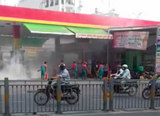 加油站人員連忙使用小型滅火器以控制火勢。（圖源：網絡視頻截圖）