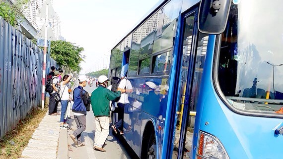 不少乘客在酷熱天氣下站在河內公路上第二郡路段等候巴士。