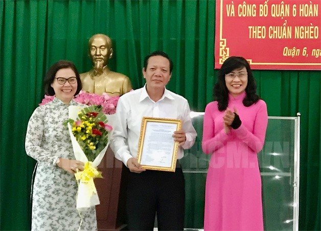 市人委會副主席阮氏秋(右)向第六郡領導頒發“無貧窮戶之郡”《公認決定書》。（圖源：市黨部新聞網）