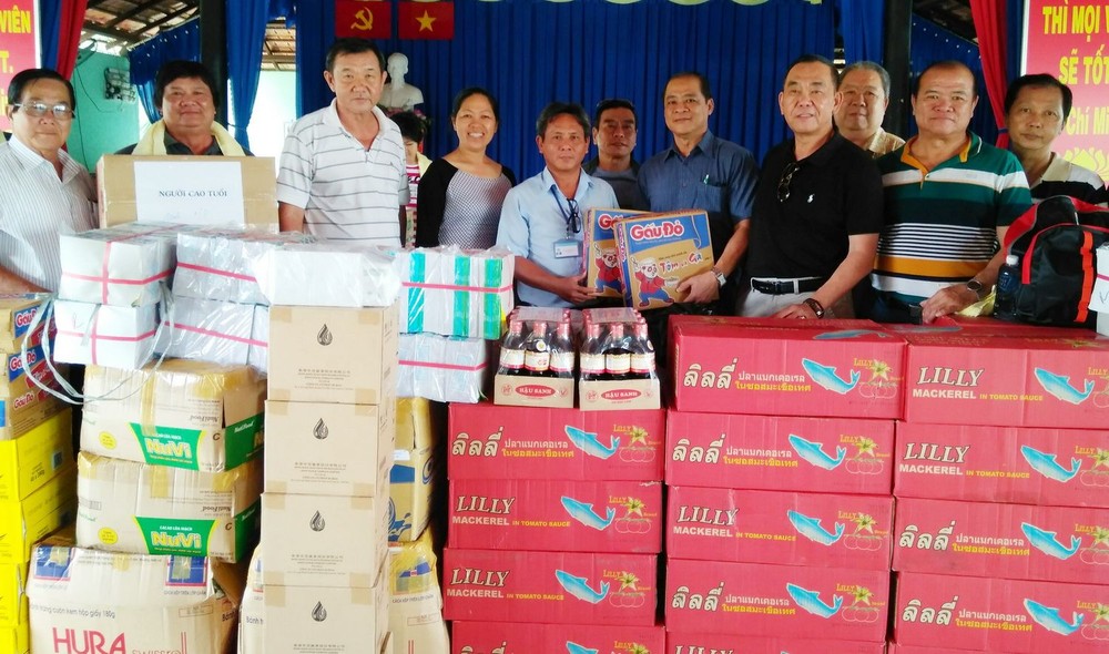 慈善組代表盧榮德（右）向阮文勇副主任移交濟助品。