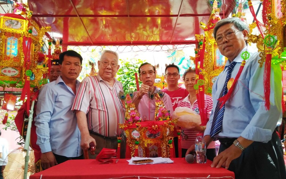 該廟名譽會長梁漢沾(左二)把首盞聖燈交予得主羅楚超先生。