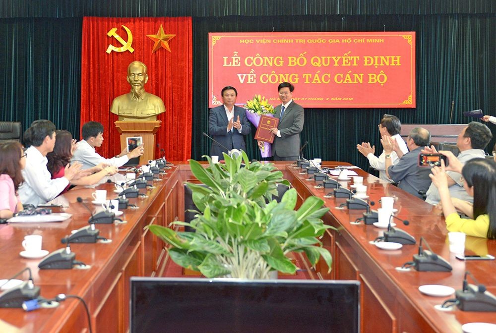 黨中央書記、中央理論委員會主席、胡志明國家政治學院院長阮春勝教授(中左)向國家與法律院副院長張胡海副教授頒發國家與法律院代院長職務的委任《決定》。（圖源：孟勝）