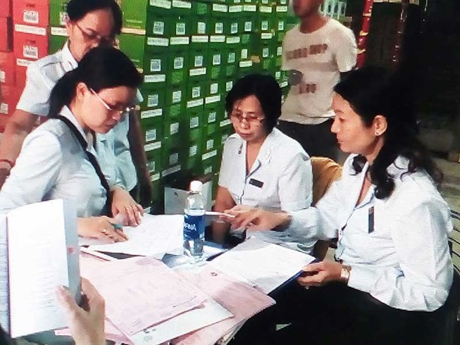 市食品安全管委會正檢查某單位的食品經營活動。