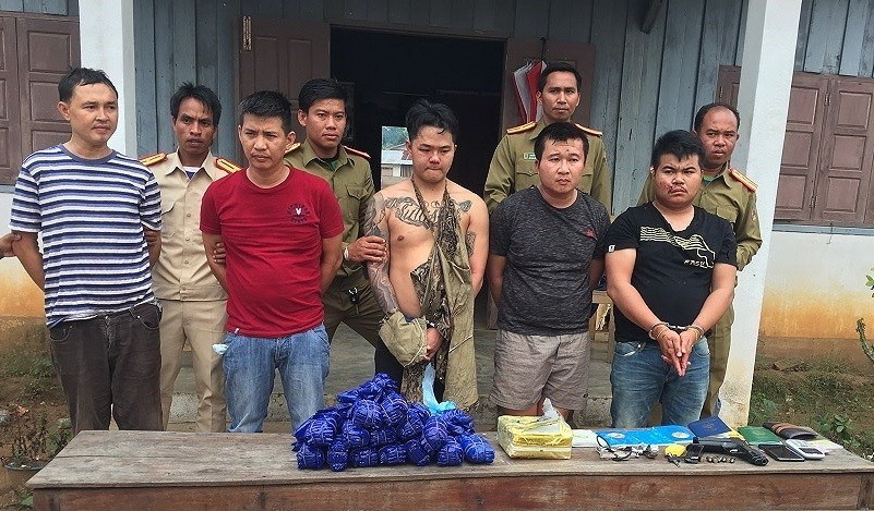 被抓獲的5名老撾籍嫌犯(前排)與涉案贓物綜合毒品、冰毒及其他物證。（圖源：孟雄）