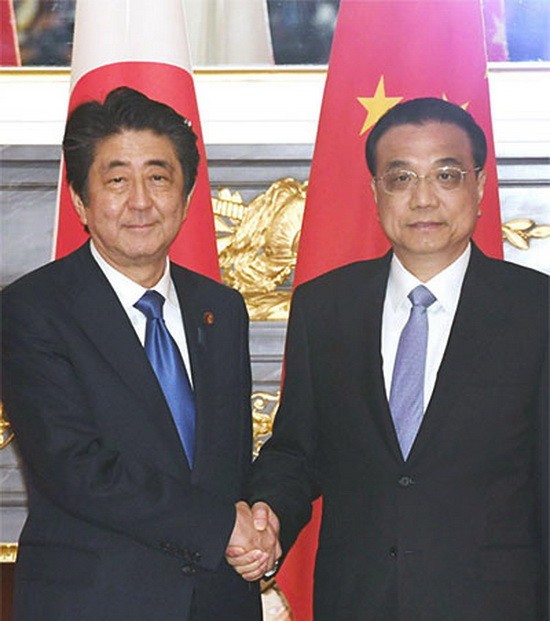 在會談前握手的日本首相安倍晉三和中國國務院總理李克強。(圖源: 日本經濟新聞)