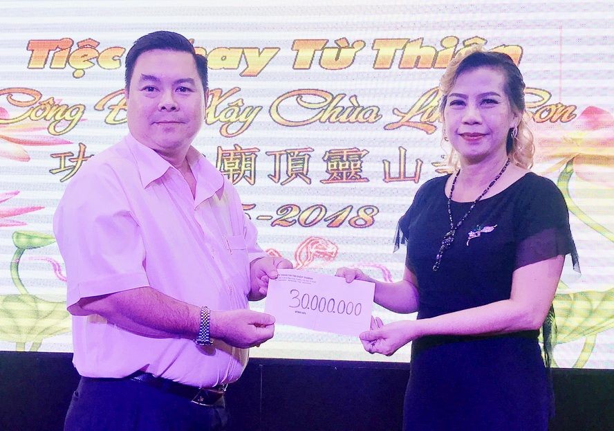 丁文森先生(左)把3000萬元交給 梁美美轉交靈山寺。