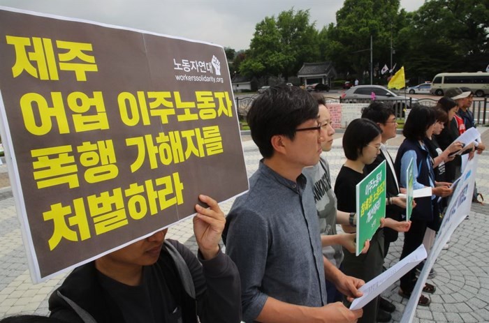 眾人集中在漢城的韓國總統辦事處外面高舉要求懲處某漁船船長涉嫌毒打兩名越南漁民事件的標語牌。（圖源：韓國時報）