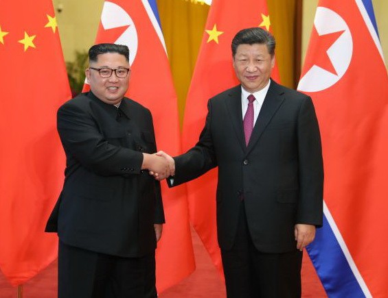 習近平(右)與金正恩握手致意。 (圖源:新華網)