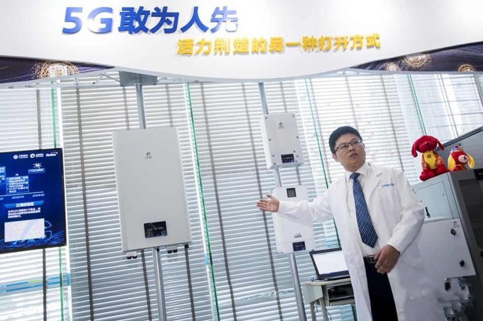 2018年2月1日,湖北首個室外5G試驗基站在武漢開通,這意味著5G技術在湖北的規模組網規模試驗已進入攻堅階段。這是2月5日,工作人員介紹5G試驗基站的射頻單元。(圖源:新華網)