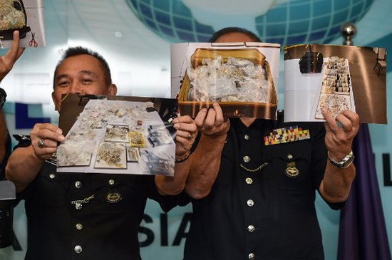 大馬警方向媒體展示財物照片。(圖源:AFP)